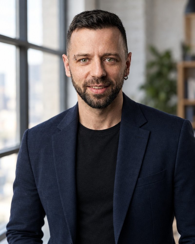 Result of prompt 01: an AI business portrait of Paul Breit in a navy blazer by the window of a loft office, made from a single studio photo